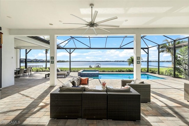 view of patio featuring a water view, a ceiling fan, a pool with connected hot tub, glass enclosure, and an outdoor hangout area