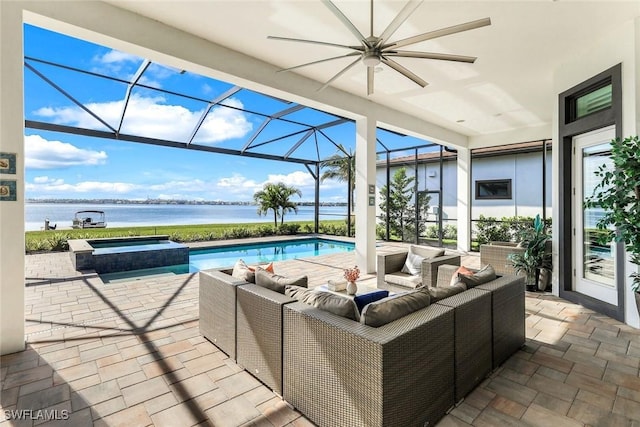 view of pool with glass enclosure, a ceiling fan, an outdoor living space, a water view, and a patio area