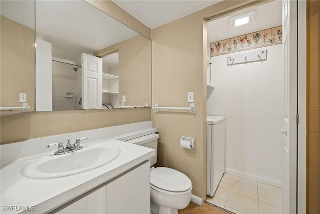 bathroom featuring vanity, tiled shower, tile patterned flooring, washer and dryer, and toilet