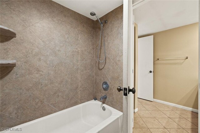 bathroom featuring tile patterned flooring, shower / bathing tub combination, and baseboards