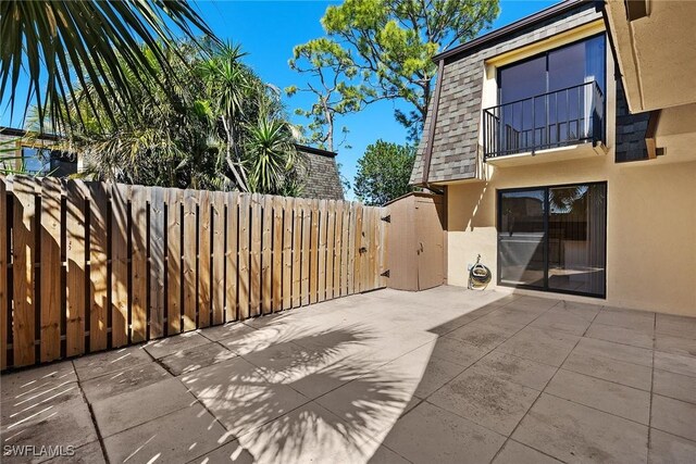 view of patio / terrace with a balcony and fence