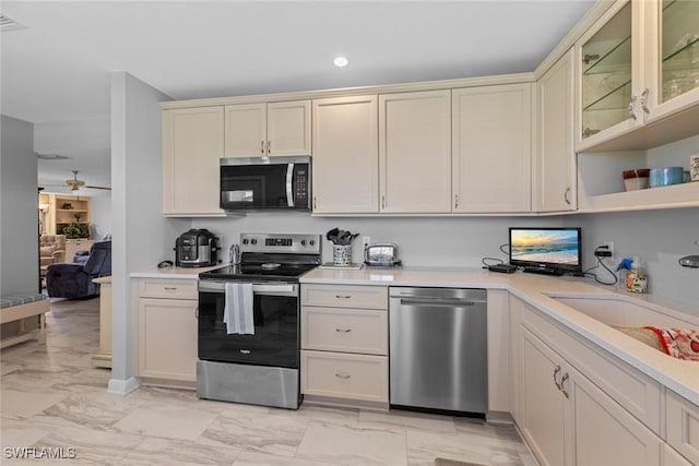 kitchen with a sink, light countertops, marble finish floor, and stainless steel appliances