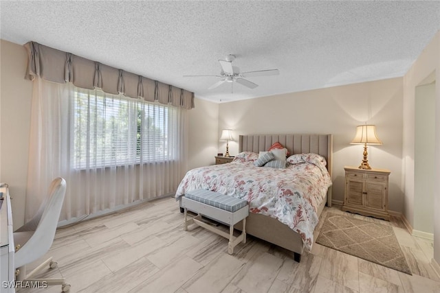 bedroom featuring baseboards, a textured ceiling, and a ceiling fan