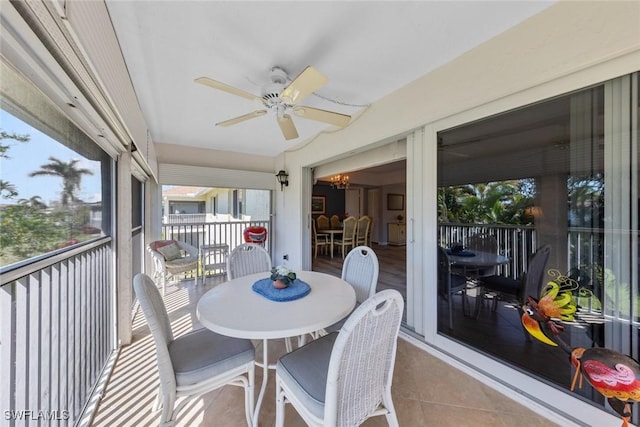 sunroom featuring ceiling fan with notable chandelier