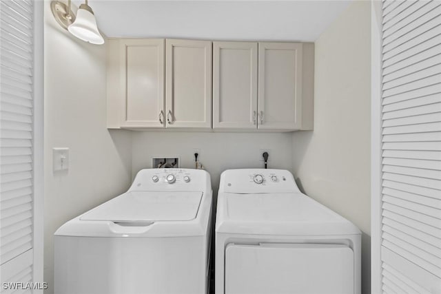 washroom with cabinet space and separate washer and dryer