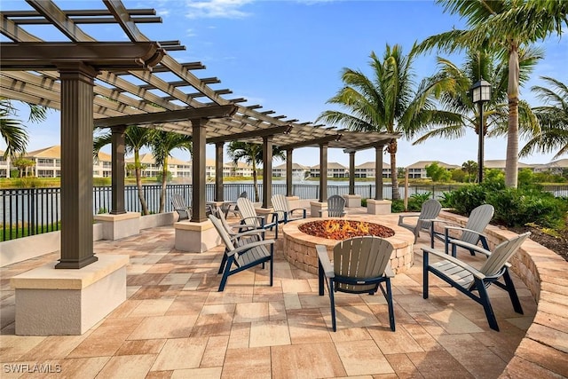 view of patio / terrace featuring fence, a pergola, a water view, and an outdoor fire pit