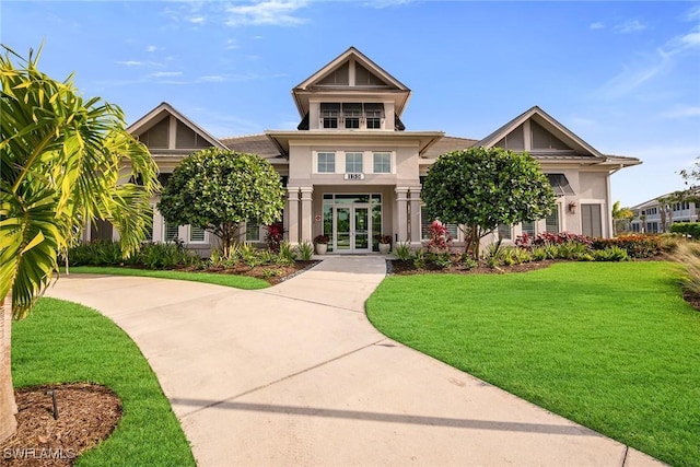 craftsman-style house with stucco siding, french doors, and a front lawn