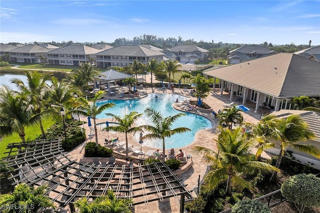 community pool featuring a gazebo, a patio area, a residential view, and a water view