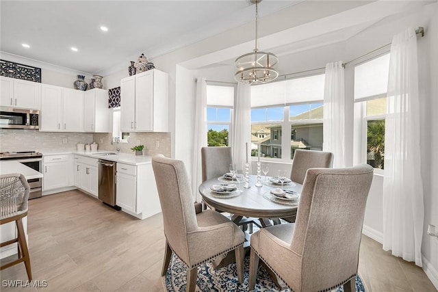 dining space with a healthy amount of sunlight, a chandelier, and ornamental molding