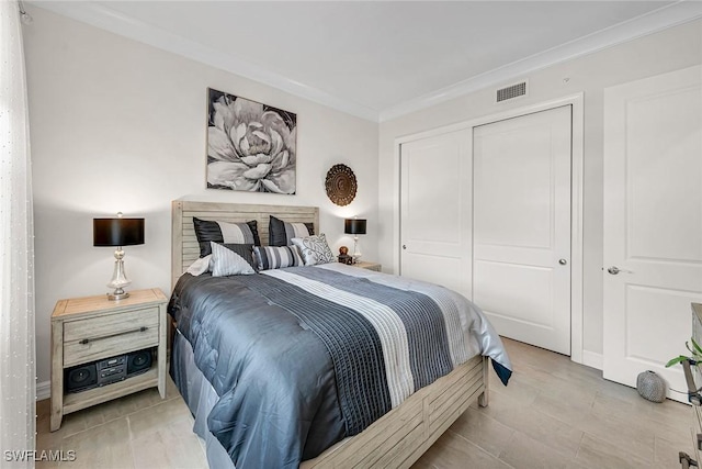 bedroom with visible vents, a closet, and ornamental molding