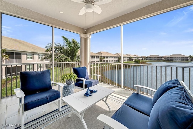 sunroom / solarium featuring a residential view, a water view, and a ceiling fan