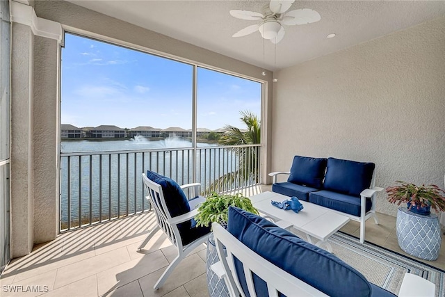 sunroom / solarium with a water view and ceiling fan