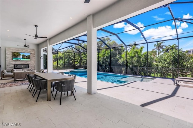 view of pool featuring a pool with connected hot tub, a lanai, an outdoor hangout area, a patio, and a ceiling fan