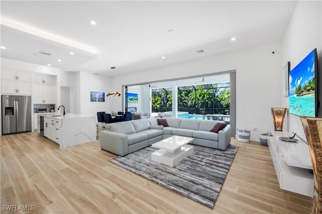 living area with light wood-style flooring, recessed lighting, and visible vents