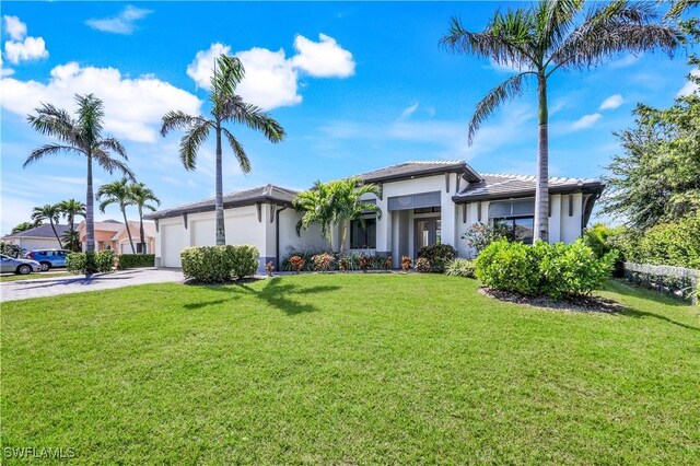 view of front facade featuring a front lawn, concrete driveway, a garage, and stucco siding