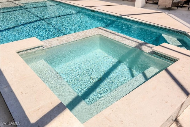 view of pool featuring a pool with connected hot tub and a patio