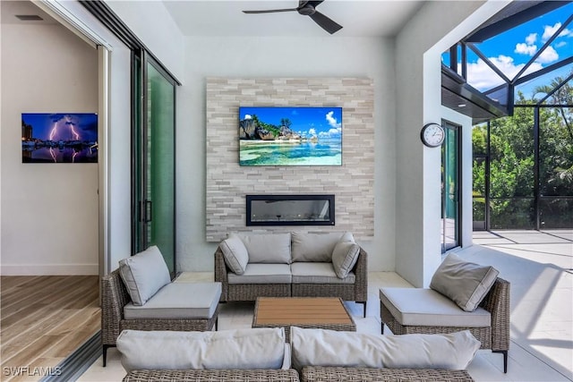 living room with a ceiling fan, wood finished floors, baseboards, and a sunroom