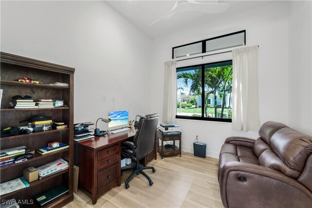 office with baseboards, lofted ceiling, and light wood-style floors