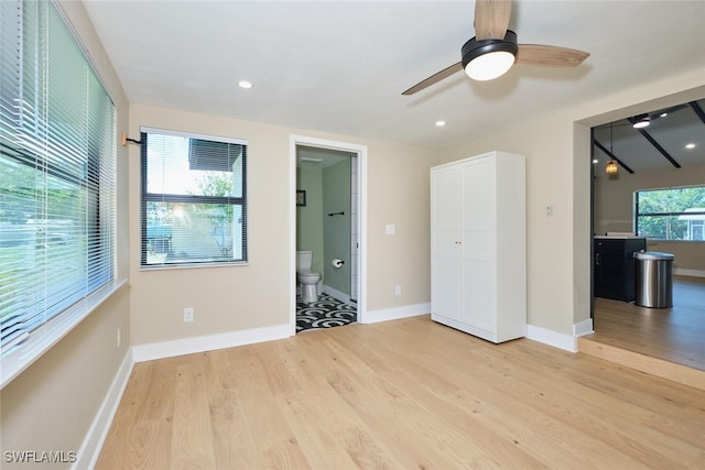 unfurnished bedroom featuring ensuite bath, recessed lighting, light wood-style floors, and baseboards