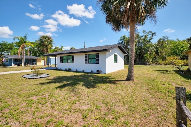 single story home with stucco siding and a front yard