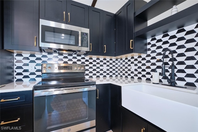 kitchen with tasteful backsplash, appliances with stainless steel finishes, light countertops, and dark cabinetry