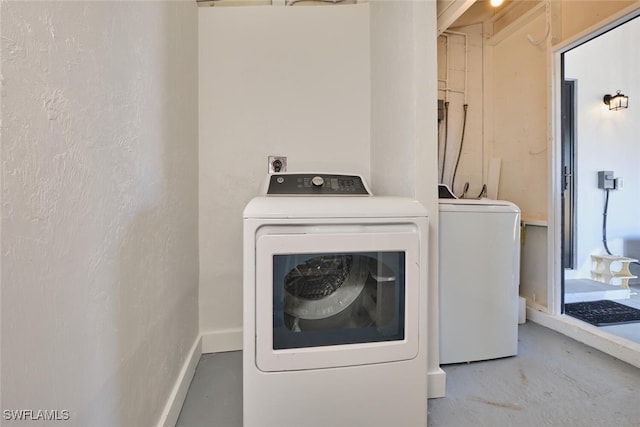 laundry area featuring baseboards, separate washer and dryer, and laundry area