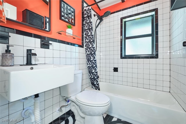 full bath featuring toilet, tile walls, shower / tub combo, and a sink