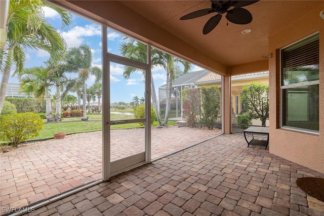 unfurnished sunroom with a ceiling fan