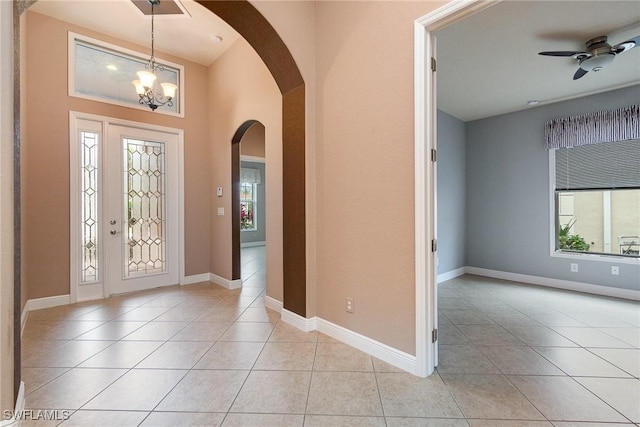 entryway with a wealth of natural light, baseboards, and light tile patterned flooring