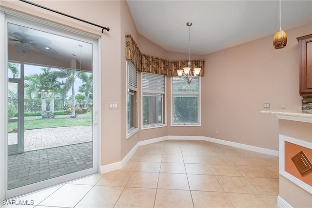 unfurnished dining area featuring light tile patterned floors, baseboards, and a notable chandelier