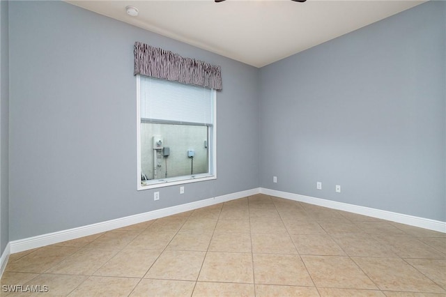 unfurnished room with light tile patterned flooring, baseboards, and ceiling fan