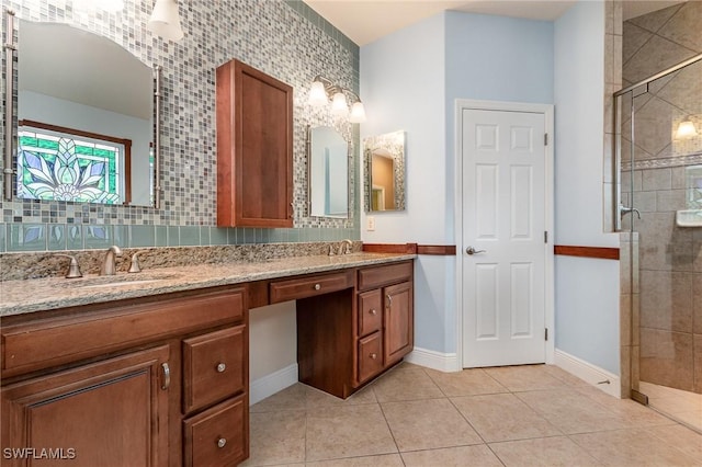 bathroom featuring tile patterned floors, a stall shower, double vanity, and a sink