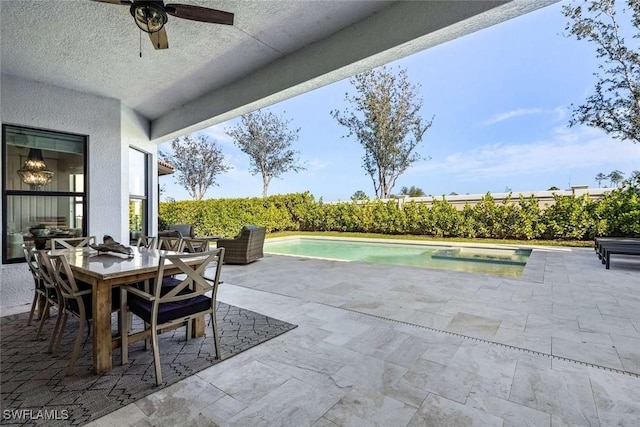 view of patio with a fenced in pool, ceiling fan, and outdoor dining space