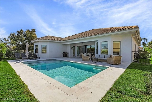 back of property with an outdoor living space, a tile roof, stucco siding, a patio area, and an outdoor pool