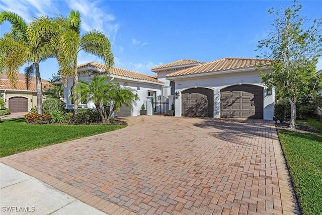 2906 Cinnamon Bay Cir, Naples, FL 34119 - mediterranean / spanish house with a tiled roof, decorative driveway, and a garage