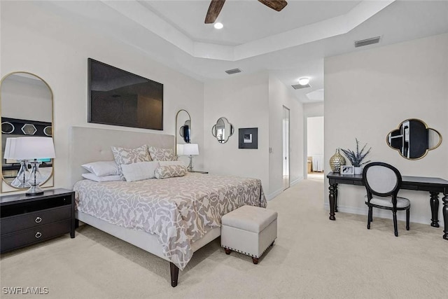 carpeted bedroom with visible vents, a ceiling fan, a raised ceiling, and baseboards