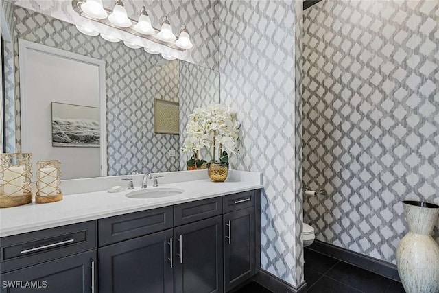 full bathroom with tile patterned floors, toilet, vanity, and wallpapered walls