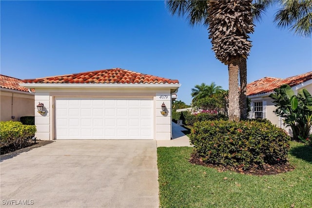 mediterranean / spanish house with a garage, concrete driveway, stucco siding, and a tile roof