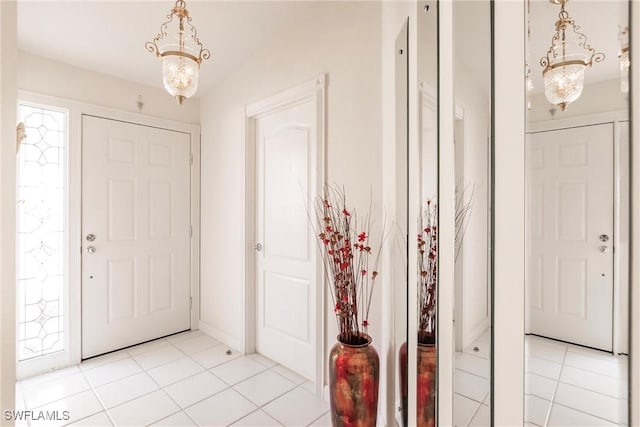 entryway featuring light tile patterned floors and an inviting chandelier