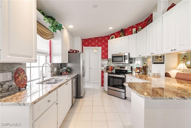 4079 Los Altos Ct, Naples, FL 34109 - kitchen with stainless steel appliances, a sink, white cabinets, a peninsula, and light tile patterned floors