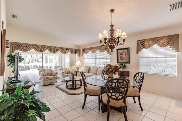 dining room featuring lofted ceiling, light tile patterned flooring, visible vents, and a chandelier