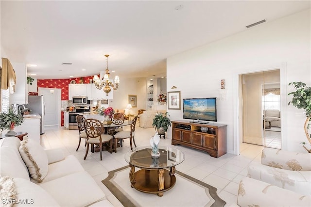 living room with light tile patterned flooring, visible vents, and an inviting chandelier