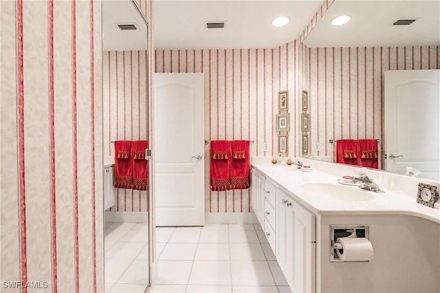 bathroom featuring tile patterned floors, visible vents, a sink, wallpapered walls, and double vanity