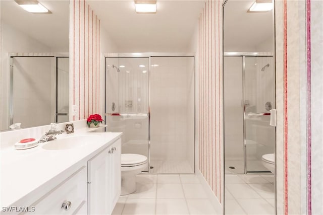 full bathroom featuring tile patterned flooring, toilet, vanity, and a stall shower