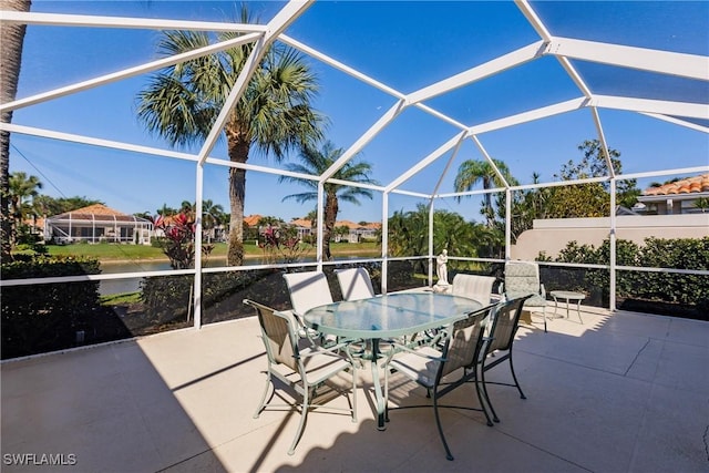 view of patio with outdoor dining space and glass enclosure