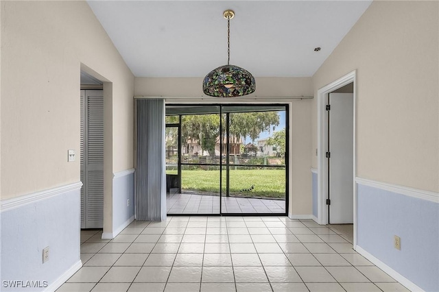 unfurnished room featuring light tile patterned flooring, baseboards, and vaulted ceiling