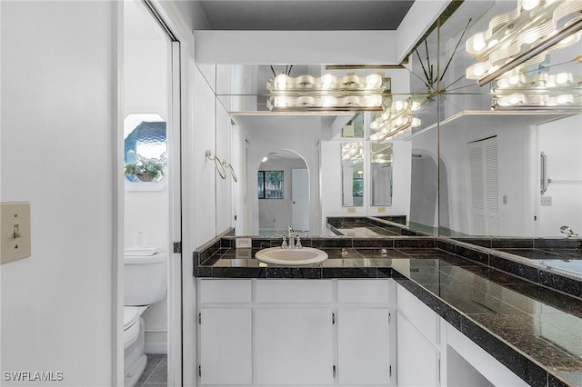 full bathroom featuring vanity, an inviting chandelier, and toilet