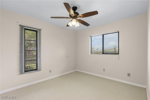 carpeted empty room with baseboards and ceiling fan