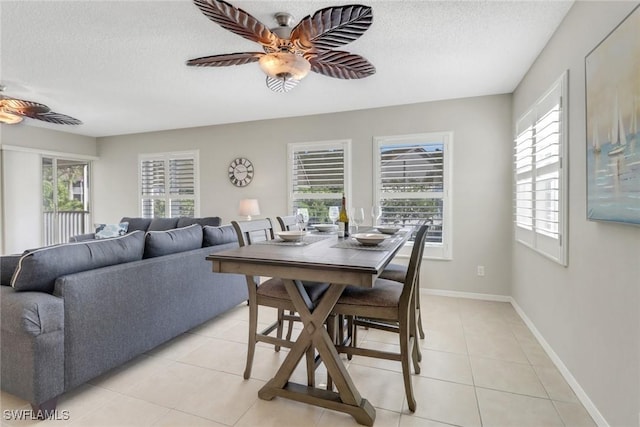 dining room with a textured ceiling, light tile patterned flooring, a healthy amount of sunlight, and ceiling fan