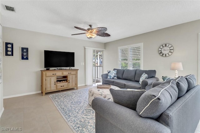 living area with light tile patterned floors, visible vents, a textured ceiling, and ceiling fan